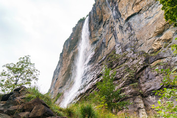 Waterfall and huge rock. Valley of waterfalls in Lauterbrunnen, Switzerland.
