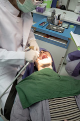 A man get check up teeth in dental hospital by dentist.
