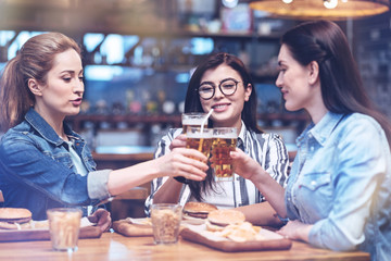 We need to relax. Happy nice young woman drinking beer and enjoying their evening while resting after work