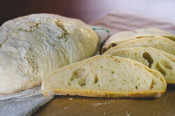 Homemade farm wheat bread, located on a linen towel and craft paper