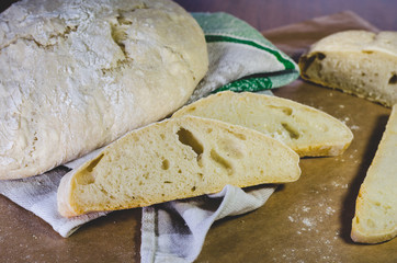 Homemade farm wheat bread, located on a linen towel and craft paper