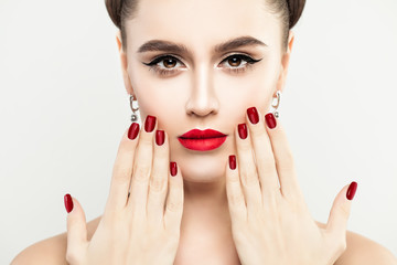 Female Face Close up. Woman Touching her Face her Hand with Manicure. Red Makeup Lips and Red Nails