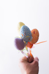 Easter eggs on a stick in a hand on a white background