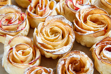 Obraz na płótnie Canvas Homemade biscuit with apples in the form of rose on baking paper