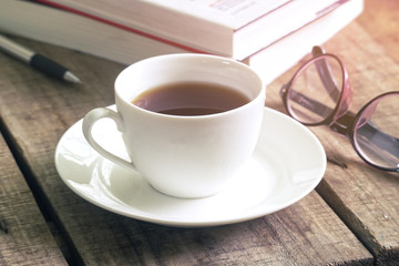 Vintage morning coffee on wood table wth glasses and text books on background