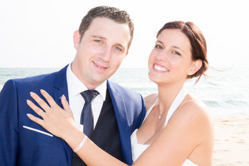 Wedding by the sea Young couple in love groom hugs a bride in a marriage dress at the ocean