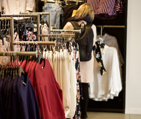 Junge Frau sieht sich die aktuellen Modetrends in einem Geschäft an