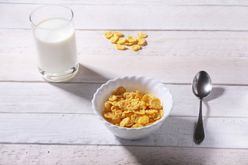 Corn Flakes cereal in a bowl and glass with milk. Morning breakfast.