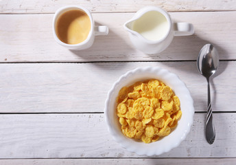 Corn Flakes cereal with milk in a bowl and cap with espresso coffee. Morning breakfast.