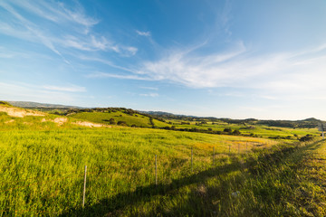 Green hills under a blue sky at sunset