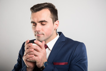 Attractive business man smelling takeaway coffee mug