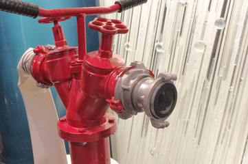 Fire hydrant red with hose connected close-up