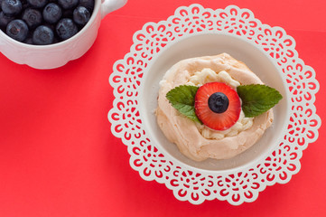 A small meringue Pavlova dessert with strawberry and mint top view