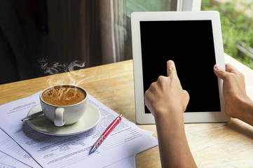Fototapeta na wymiar Asian man is using smart tablet and drinking coffee.