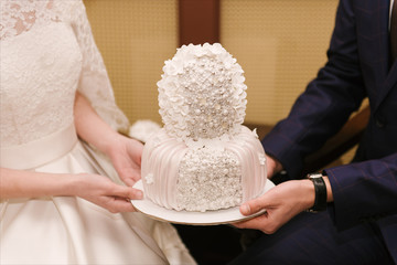 Wedding cake covered with white fondant, decorated with beads