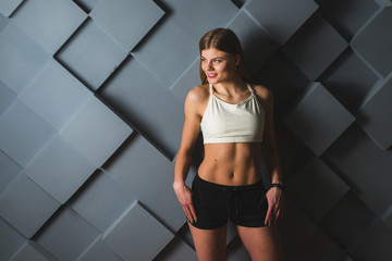 beautiful athletic girl wearing sportswear on a gray background