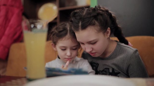 two sisters in a cafe-pizzeria see menu
