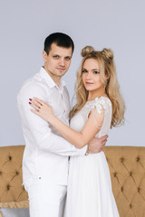 happy young couple in white clothing in a beautiful interior, family, wedding