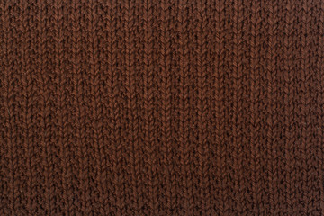 Sweater or scarf fabric texture large knitting. Knitted jersey background with a relief pattern. Wool hand- machine, handmade, brown.