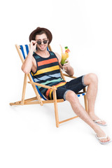 man in sunglasses and hat relaxing on beach chair with cocktail, isolated on white