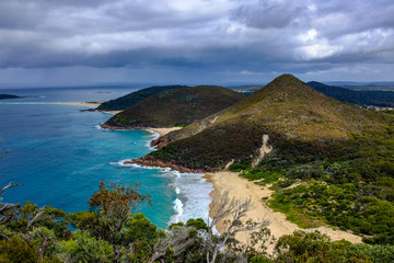 High view of ocean against tree covered mountains