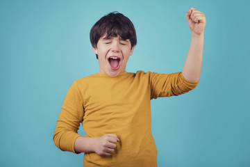 niño sonriente y eufórico sobre fondo azul