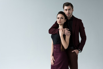 handsome man hugging his girlfriend, isolated on grey