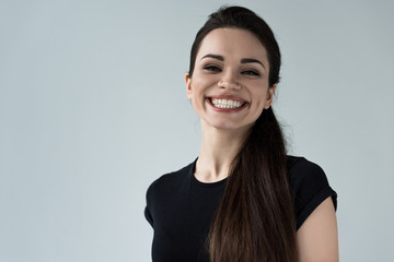 portrait of young smiling woman, isolated on grey