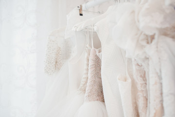 Wedding dresses for bride on hangers against white background loft store. Concept wedding,...