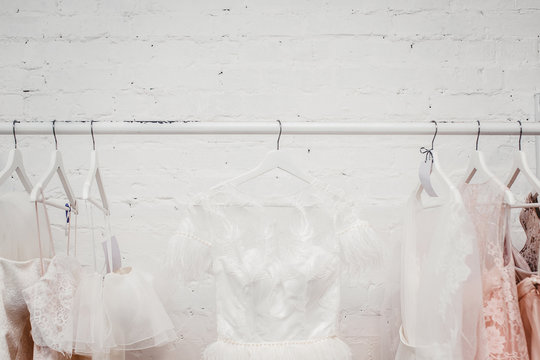 Wedding dresses for bride on hangers against white background loft store. Concept wedding, engagement, attributes, clothing, love.