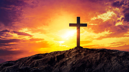 Fototapeta premium Silhouetted christian cross silhouette on the mountain at sunset