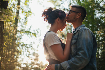 Loving couple kissing outdoor at sunset - Concept about people, love and lifestyle