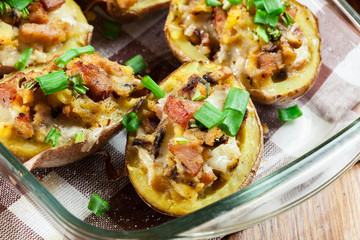 Baked potatoes in jacket stuffed with bacon, mushrooms and cheese. Dish served in baking dish..Baked potatoes stuffed with bacon, mushrooms and cheese