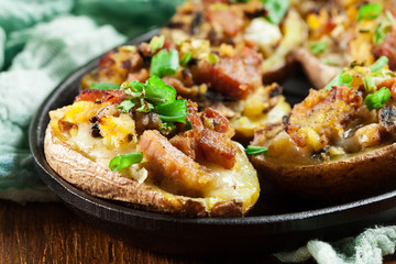 Baked potatoes in jacket stuffed with bacon, mushrooms and cheese. Dish served in baking dish..Baked potatoes stuffed with bacon, mushrooms and cheese