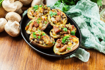 Baked potatoes in jacket stuffed with bacon, mushrooms and cheese. Dish served in baking dish..Baked potatoes stuffed with bacon, mushrooms and cheese