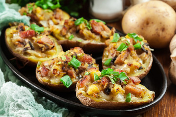 Baked potatoes in jacket stuffed with bacon, mushrooms and cheese. Dish served in baking dish..Baked potatoes stuffed with bacon, mushrooms and cheese