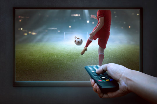 People hands with remote watching football game