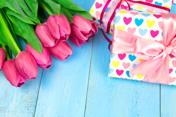 Bouquet of tulips on blue wooden table with gift box. Happy women's day. 8 March., Mother's Day. Flat lay and copy space