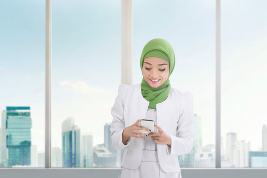 Beautiful asian muslim woman with mobile phone