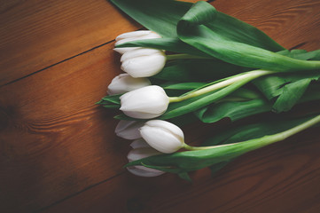 white tulips on a wooden brown table