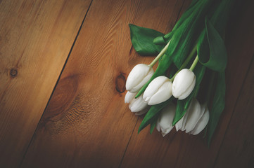 white tulips on a wooden brown table