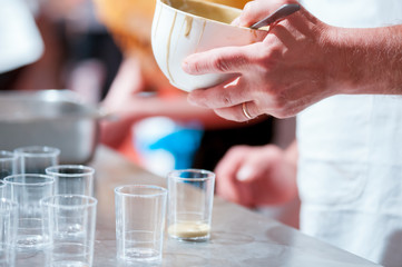 Confectioner preparing cream in pastry shop, food industry