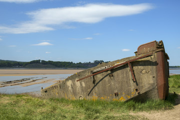 Fototapeta premium Obsolete old boats and barges were stranded on the banks of the tidal River Severn in Gloucestershire, UK to protect the river banks from erosion. 