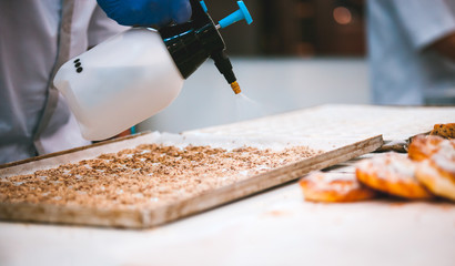 Confectioner preparing cookies on table in bakery, closeup