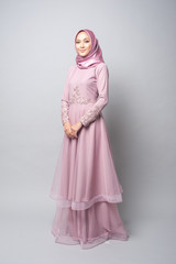 Naklejka premium Beautiful muslim girl wearing pink asian dress known as Baju Kurung with Hijab.Hijab fashion for Eid Mubarak.Studio Shoot.