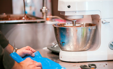 Fototapeta na wymiar Confectioner preparing cakes in pastry shop, food industry