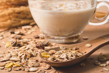 A cup of milk with cereal on wooden table. Healthy breakfast concept.