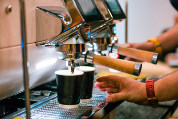 Barista preparing coffee using machine at coffee shop