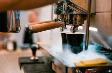 Barista preparing coffee using machine at coffee shop