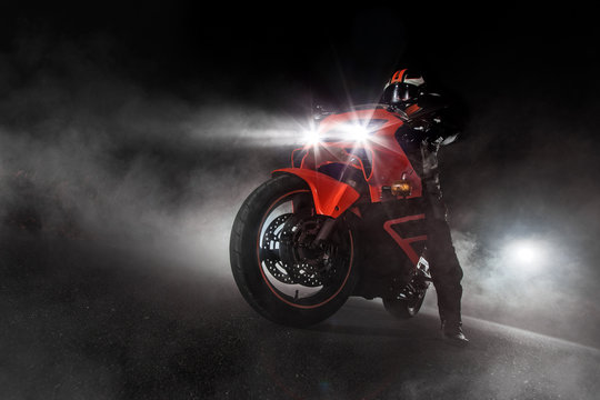 Fototapeta Supersport motorcycle driver at night with smoke around
